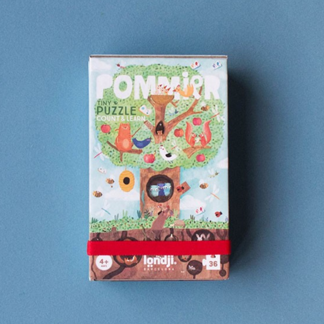 Pom Pom Tiny Puzzle box with a tree design on a blue background