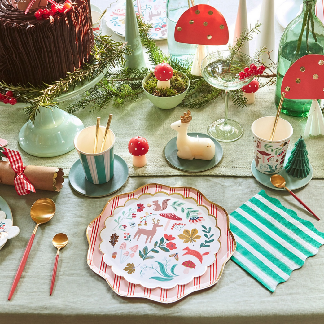  festive table setting with plates, cups, and decorations on a tablecloth.