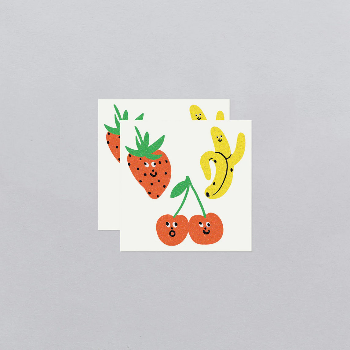 Sticker sheet with cartoon strawberries, cherries, and banana on a gray background