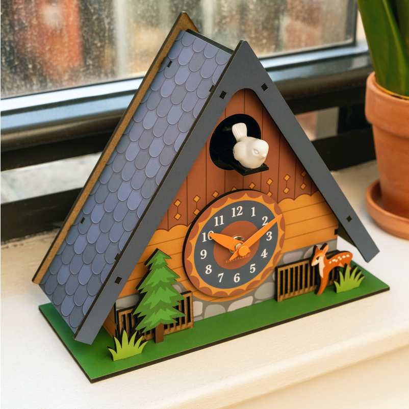 Wooden cuckoo clock with a house design on a windowsill