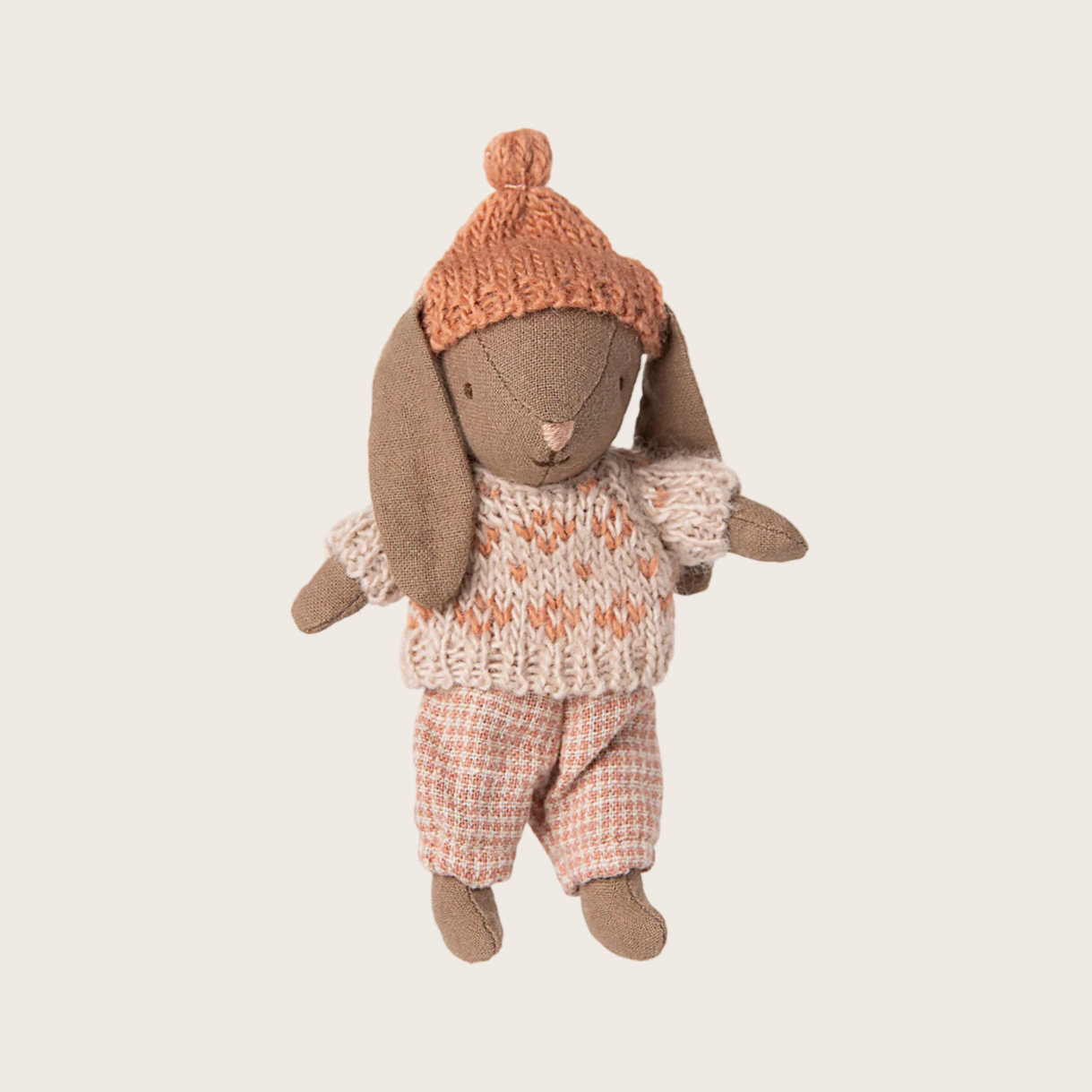 Stuffed toy rabbit wearing a knitted sweater and hat 