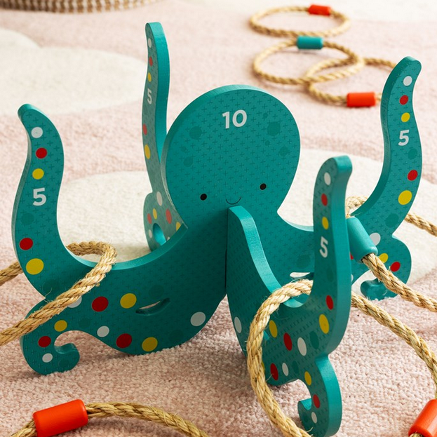 Colorful wooden octopus toy with rope on a soft surface