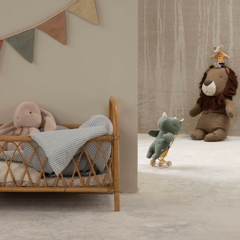 Children's room with wooden crib, stuffed animals, and decorative flags.