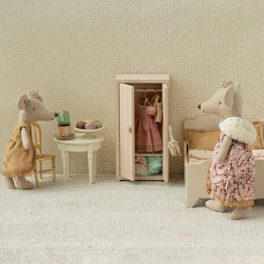 Miniature room setup with stuffed animal characters in a room with a patterned wall.
