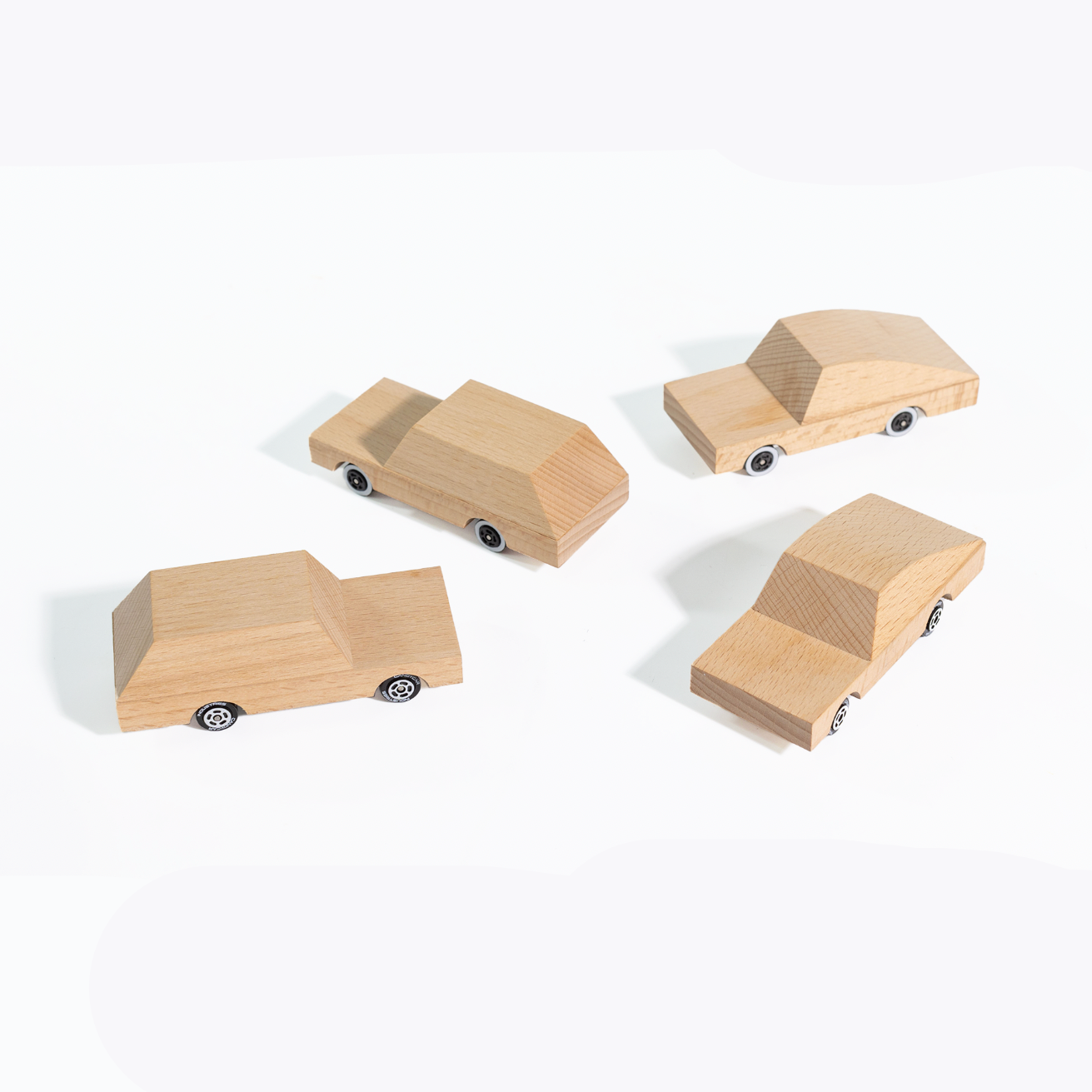 Four wooden toy cars on a white background