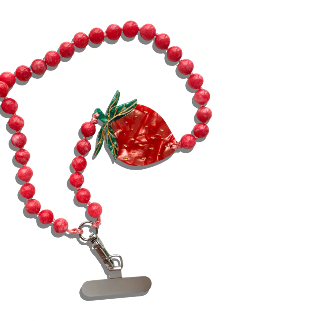 Red beaded necklace with a strawberry charm on a white background