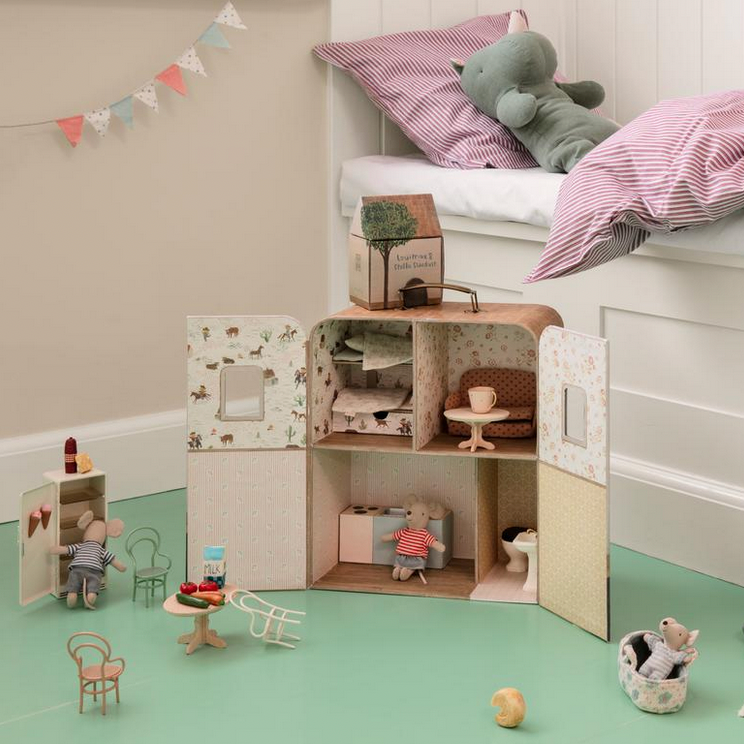 Children's room with a dollhouse, toys, and stuffed animals on a green floor.