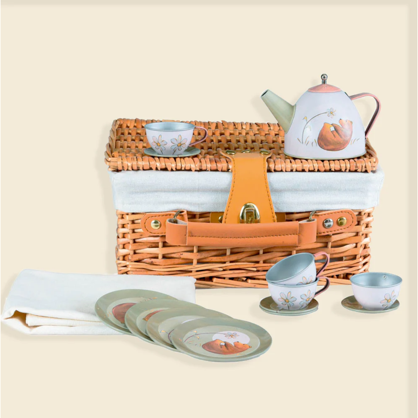 Picnic basket set with teapot, cups, and coasters on a beige background