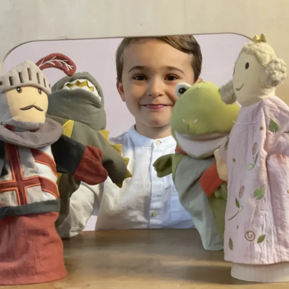 Child with hand puppets on a wooden table
