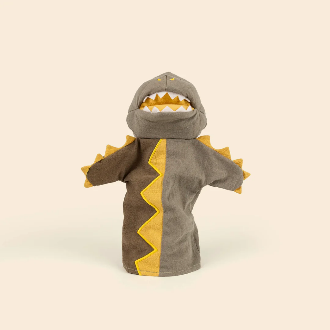 puppet designed like a dinosaur with gray hood, brown body, and yellow accents on a beige background