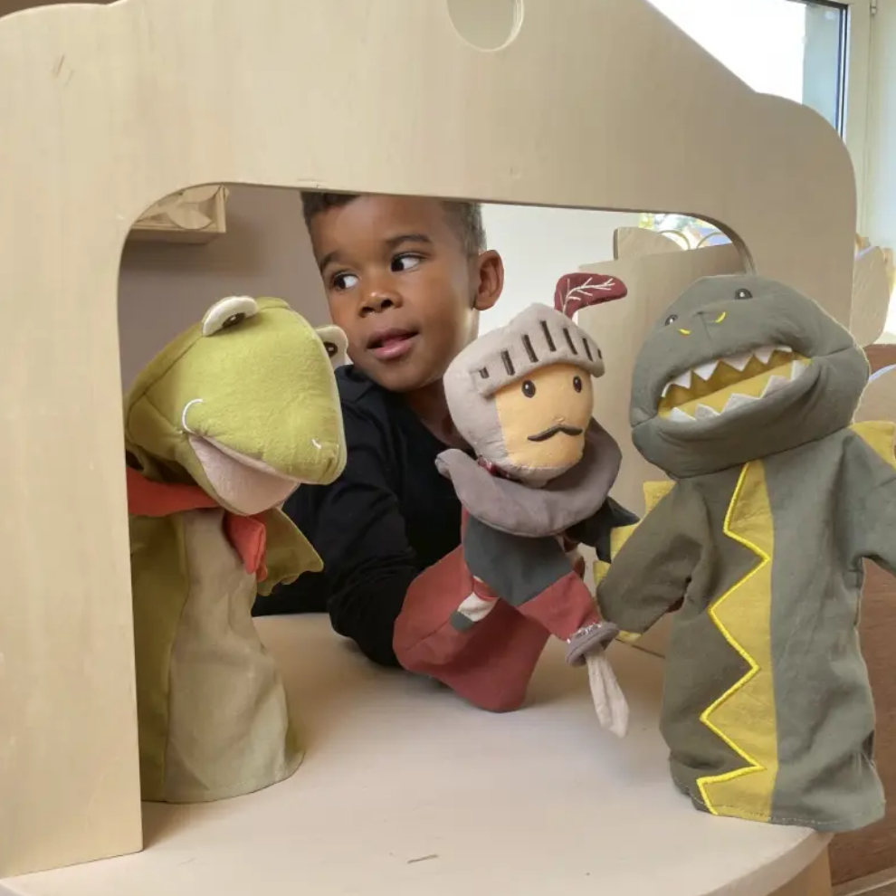 Child playing with puppet theater and colorful puppets