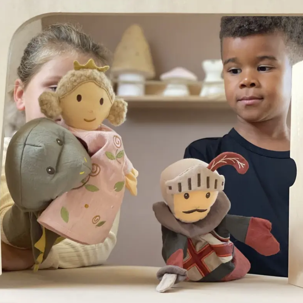Two children with toy figures of a princess and a knight in a display case.