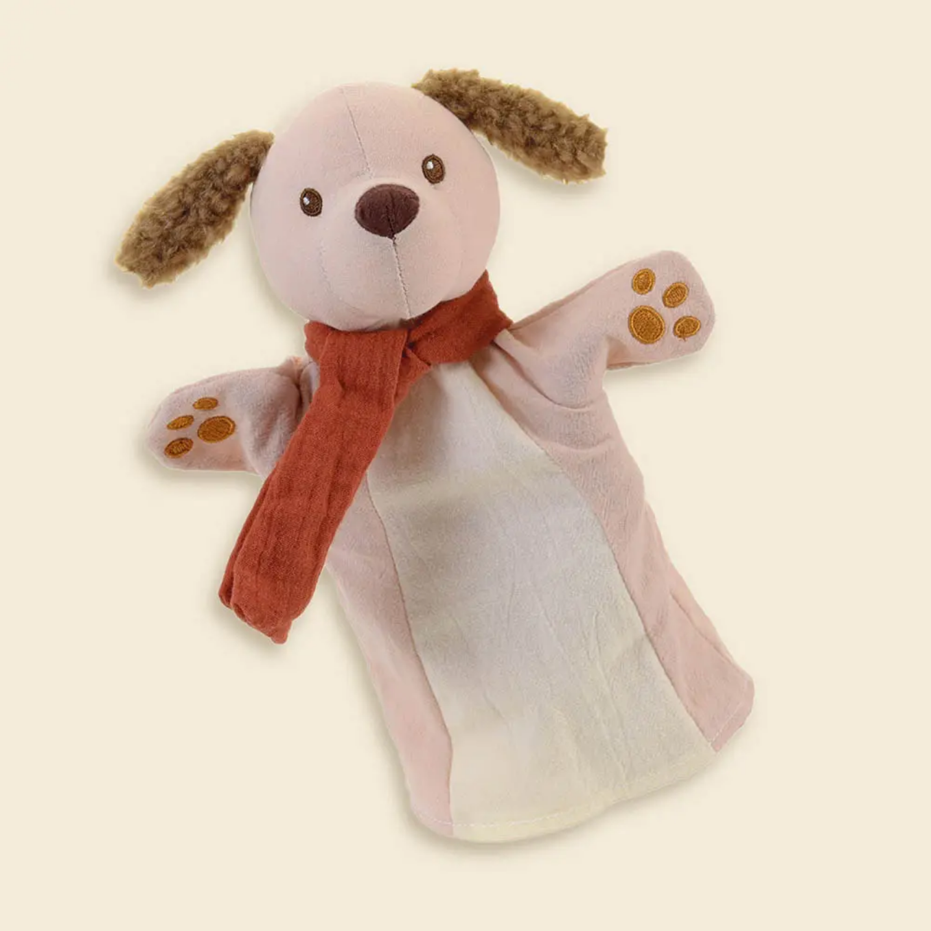 Stuffed dog puppet with a red scarf on a beige background