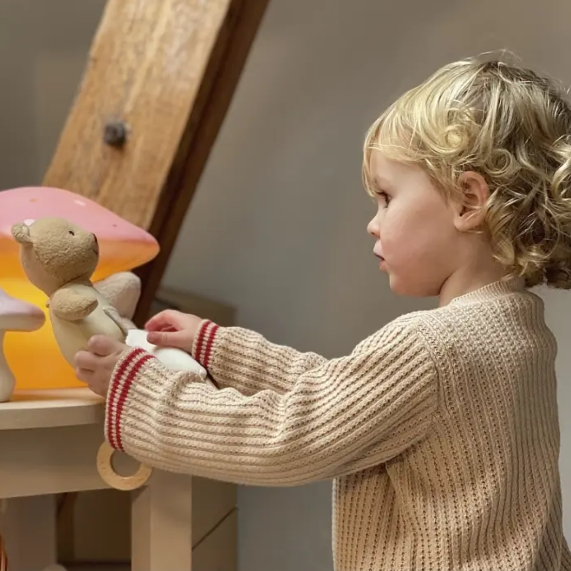 Child playing with wooden toys in a cozy indoor setting