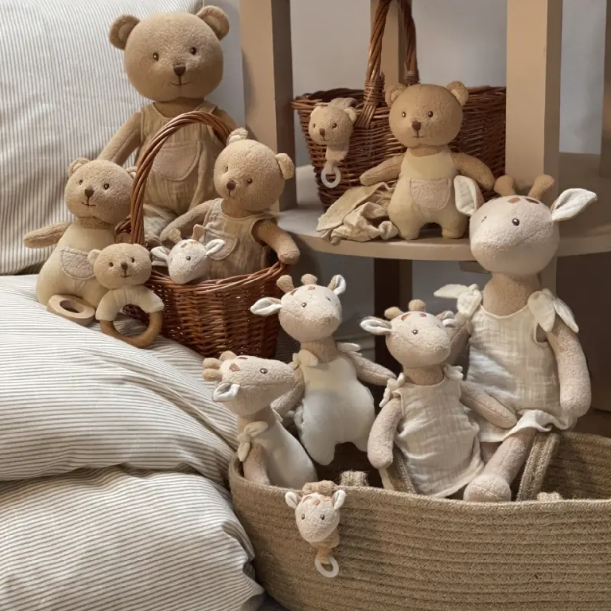 Collection of soft toys including teddy bears and bunnies in baskets on a neutral background