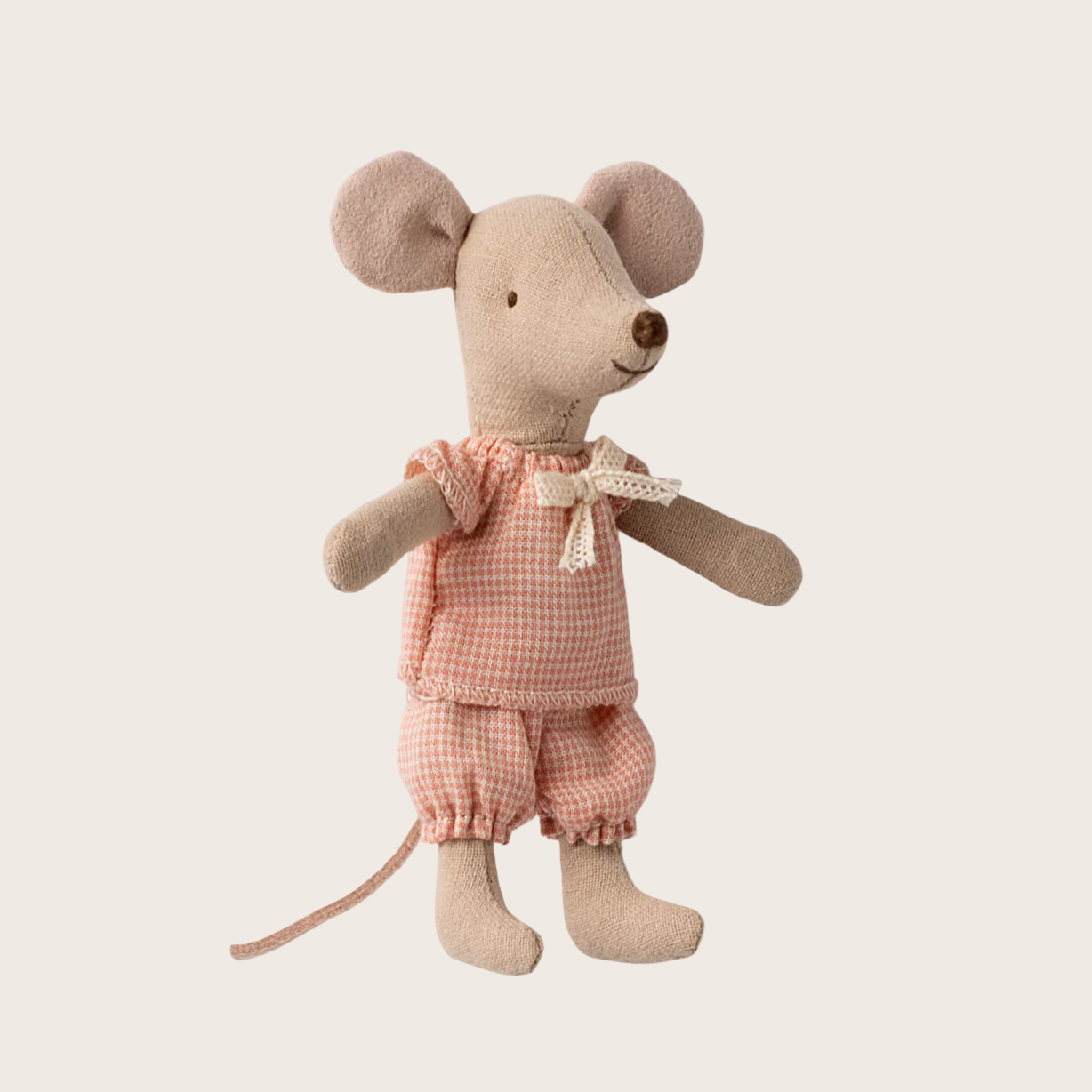 Stuffed toy mouse in a pink outfit on a beige background