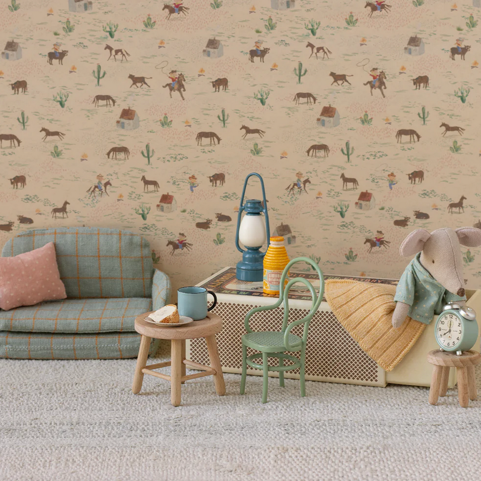 Children's room with patterned wallpaper, sofa, and small furniture set.