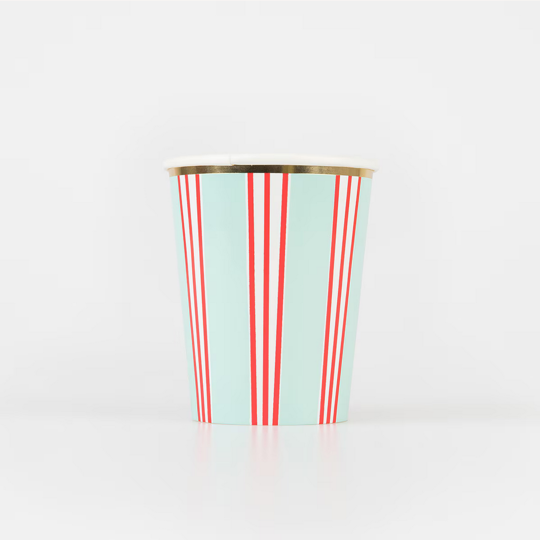 Paper cup with red and white stripes on a light blue background, gold rim