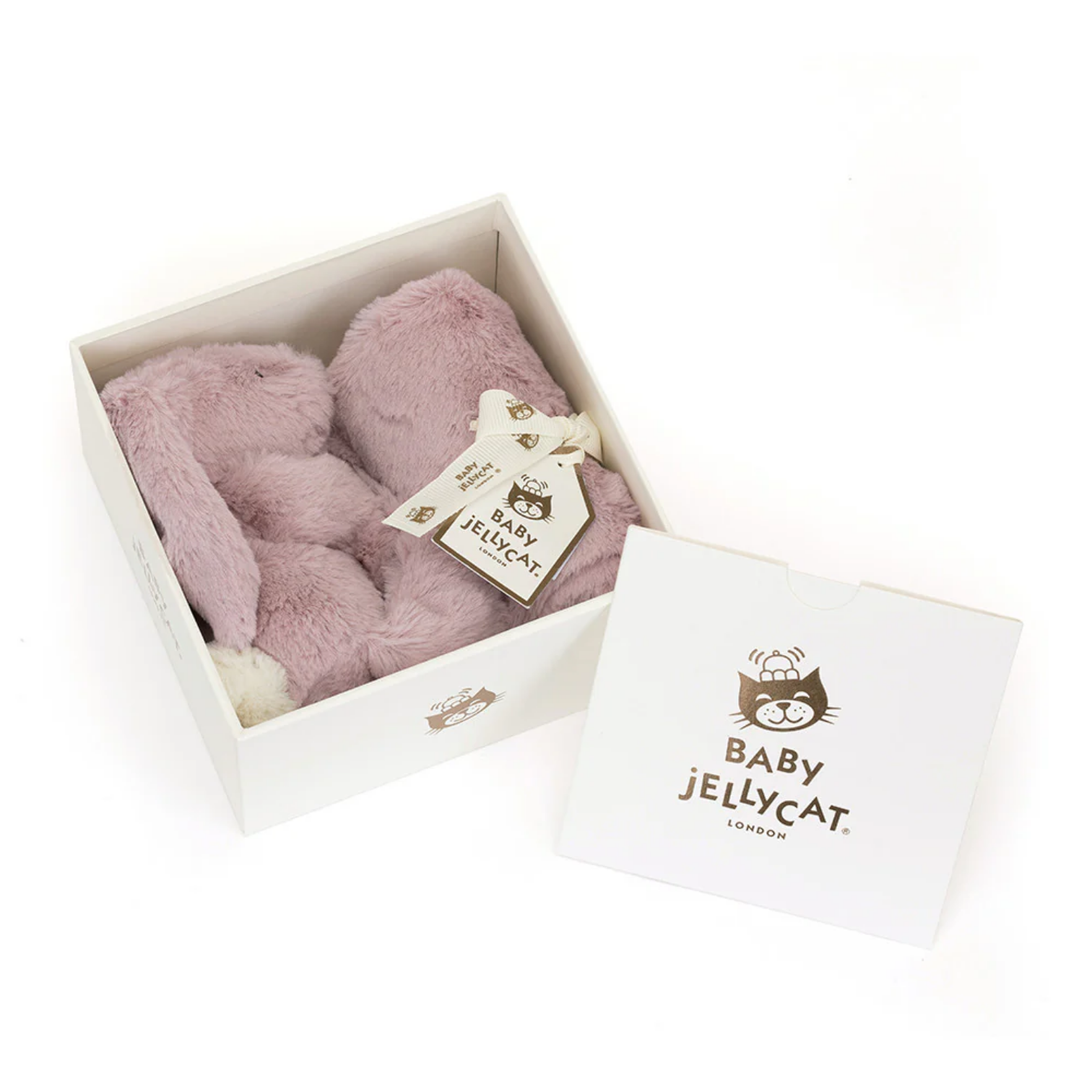 Pink plush toy in a white box with a Baby Jellycat tag on a white background