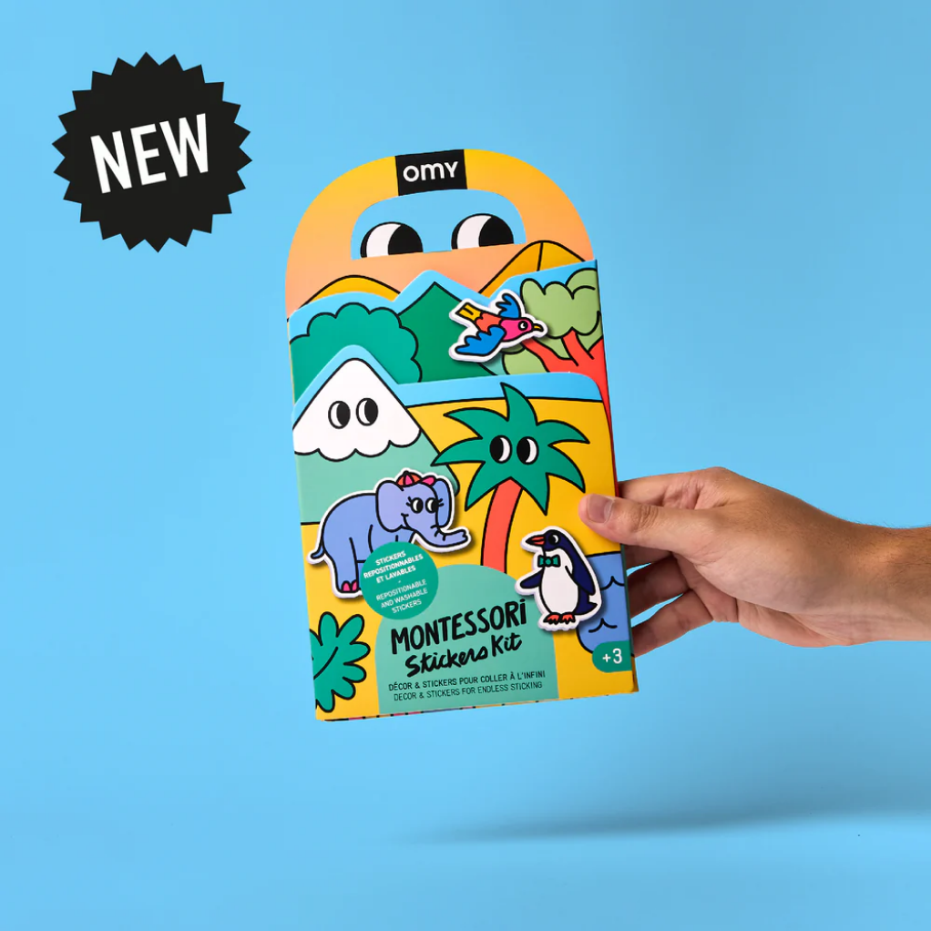Hand holding a colorful Montessori stickers kit packaging against a blue background