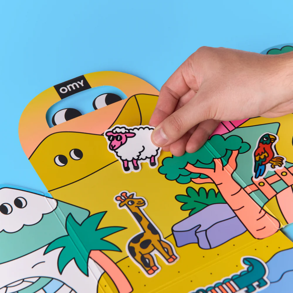 Hand placing a sheep sticker on a colorful puzzle with cartoon characters against a blue background.