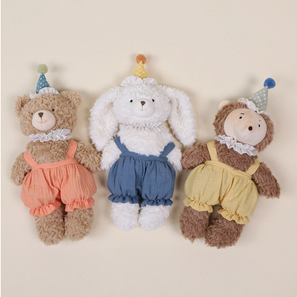 Three stuffed animals dressed in colorful outfits on a beige background