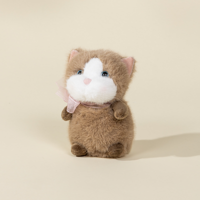 Plush toy resembling a cat with a white face on a beige background