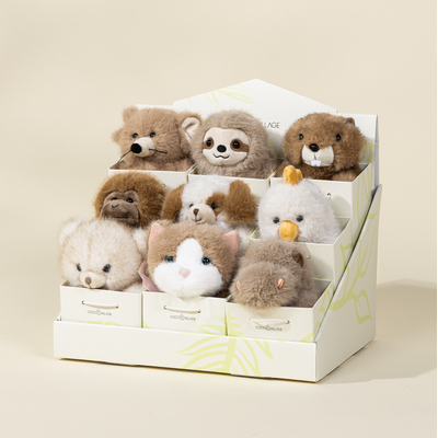 Set of small plush toys in a box on a beige background