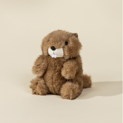 Plush toy otter on a beige background