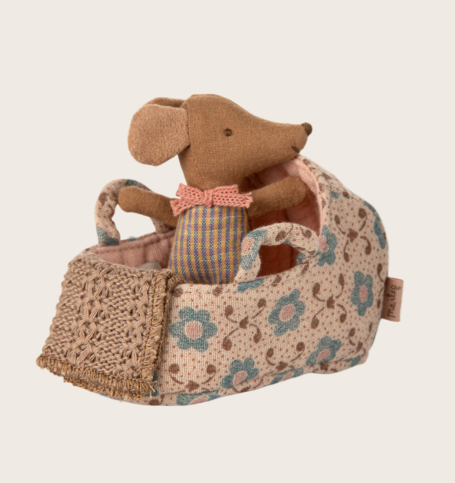 Stuffed animal in a floral-patterned carrier 