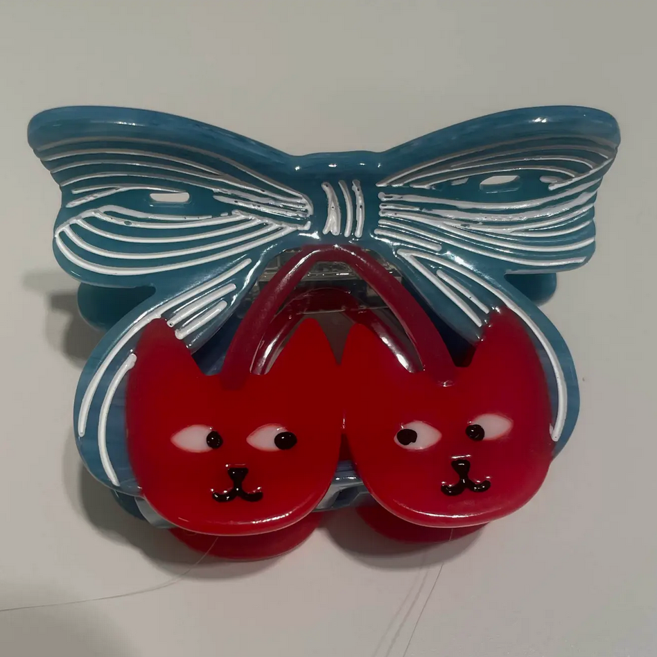 Butterfly-shaped container with red cat faces on a white background