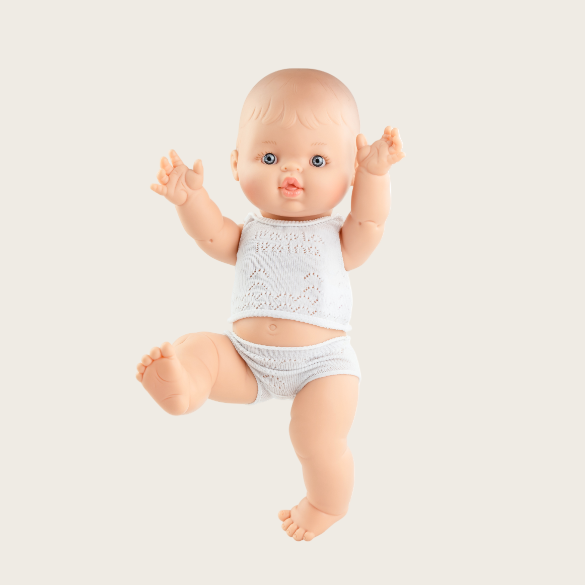 Baby doll in a gray onesie on a white background