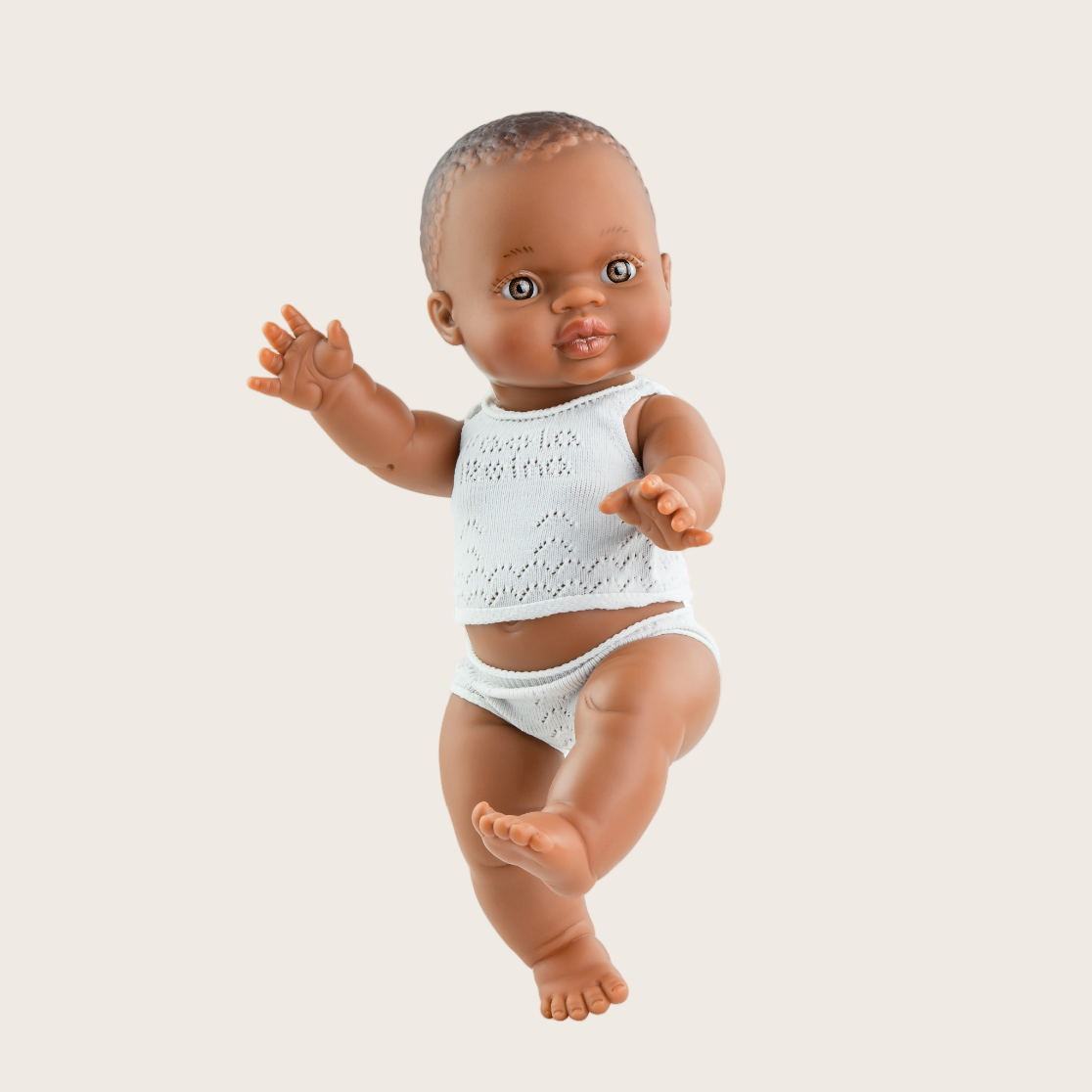 Baby doll in a white outfit on a white background