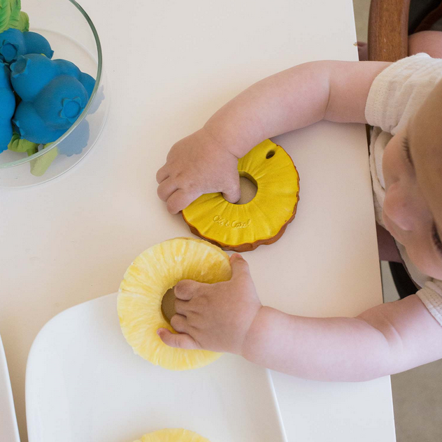 Child playing with yellow toy rings on a white surface