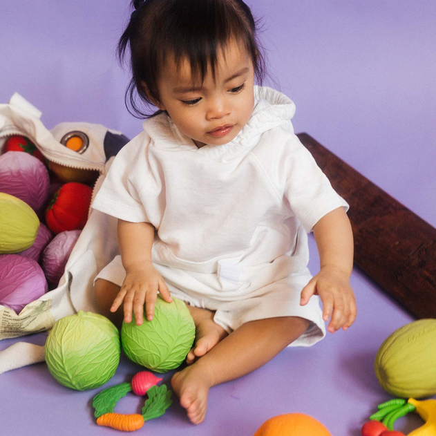 Child playing with colorful toys on a purple floor