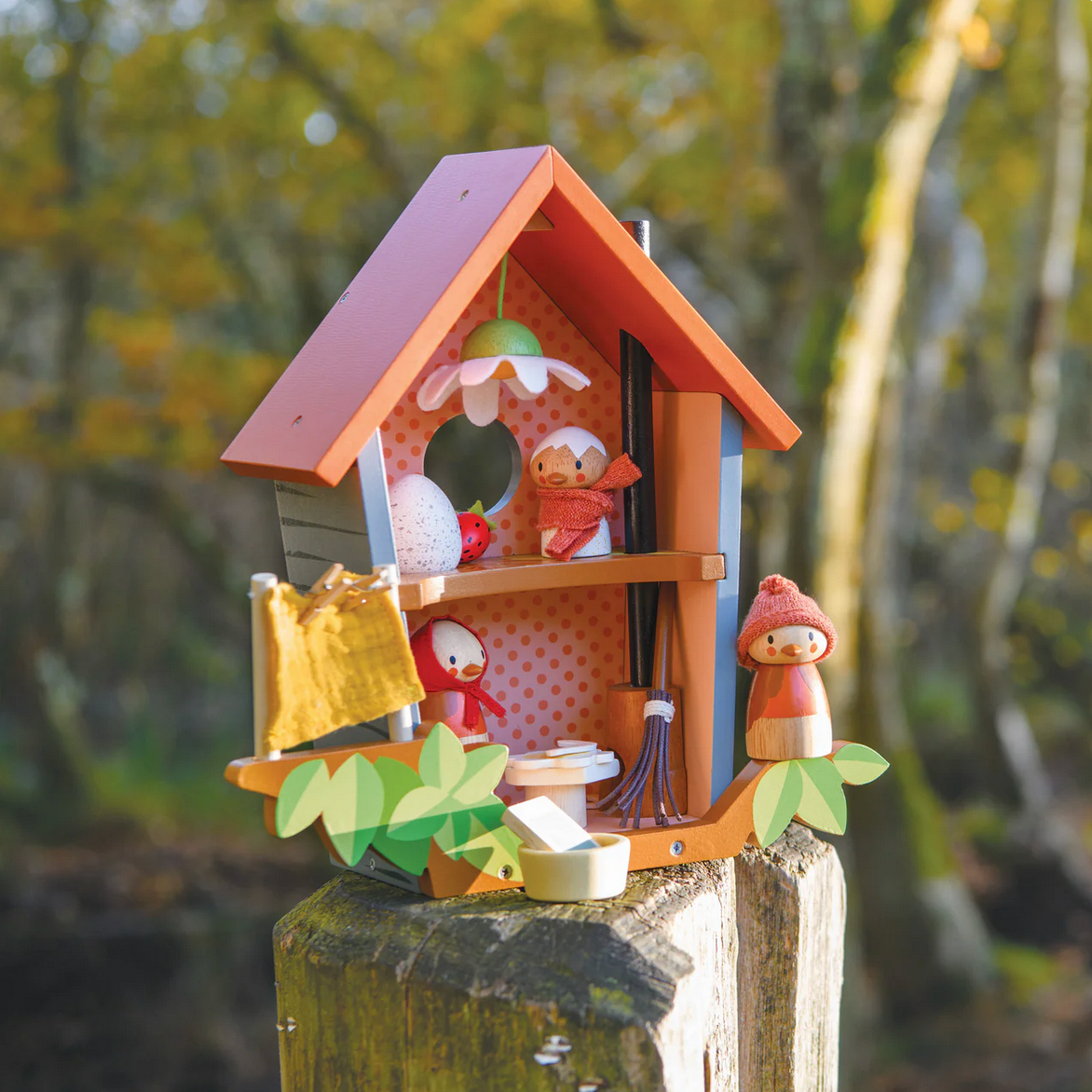 Wooden fairy house with small figurines on a natural background