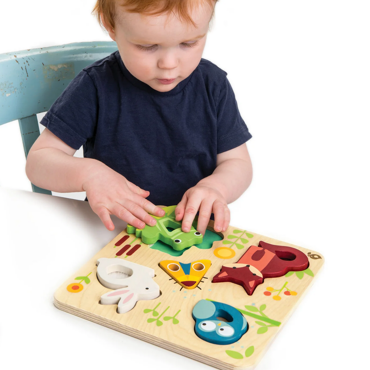Child playing with a wooden puzzle toy on a table, with a product listing visible in the background.