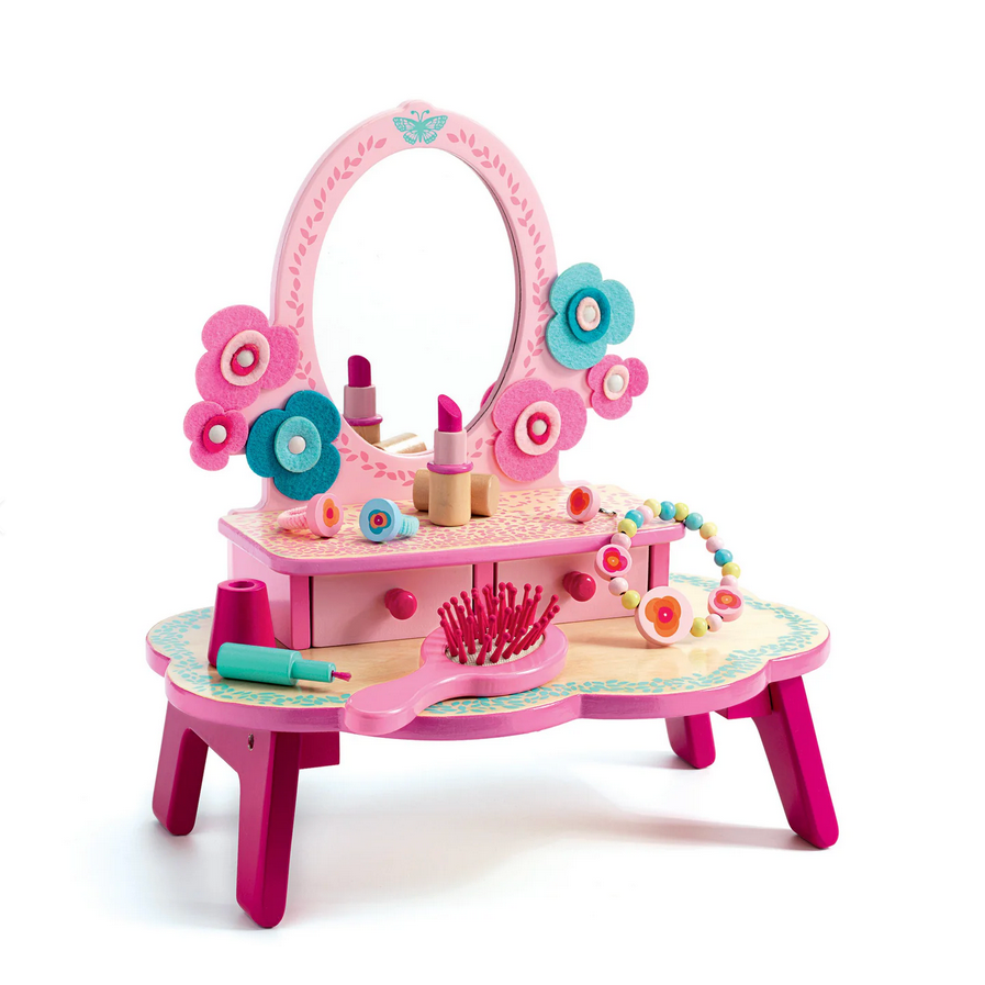 Pink toy vanity with mirror and accessories on a white background