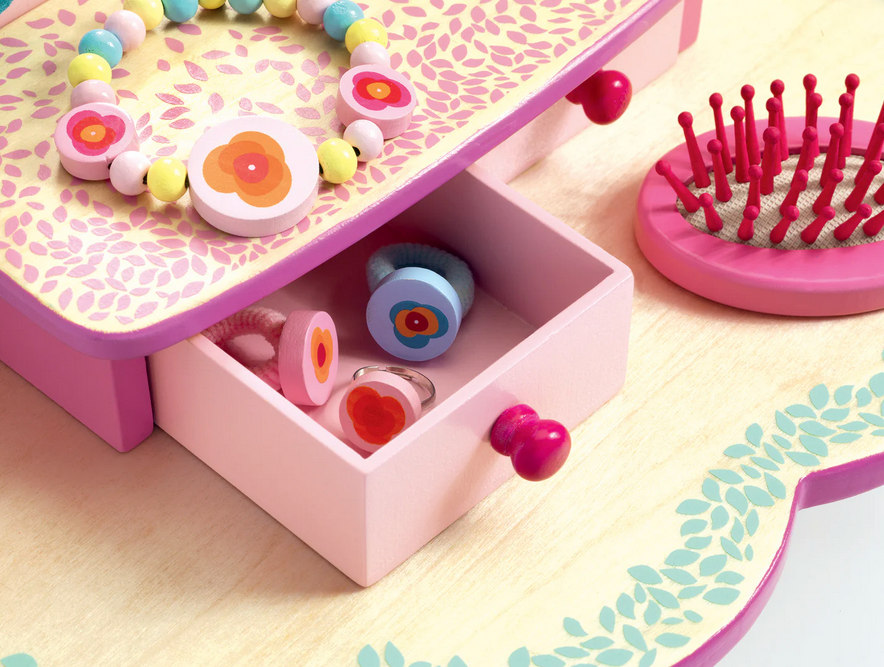 Pink jewelry box with accessories on a light surface
