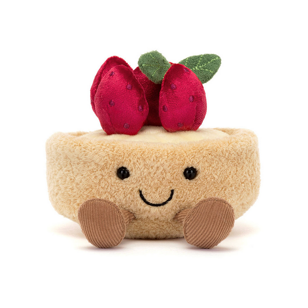 Plush toy resembling a  cheese with TART with strawberry decorations on a white background