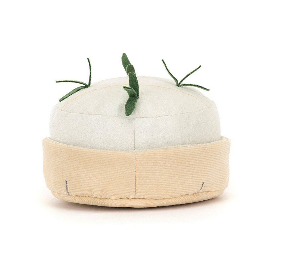 White and beige toy shaped like a cheese wheel with green stems on a white background