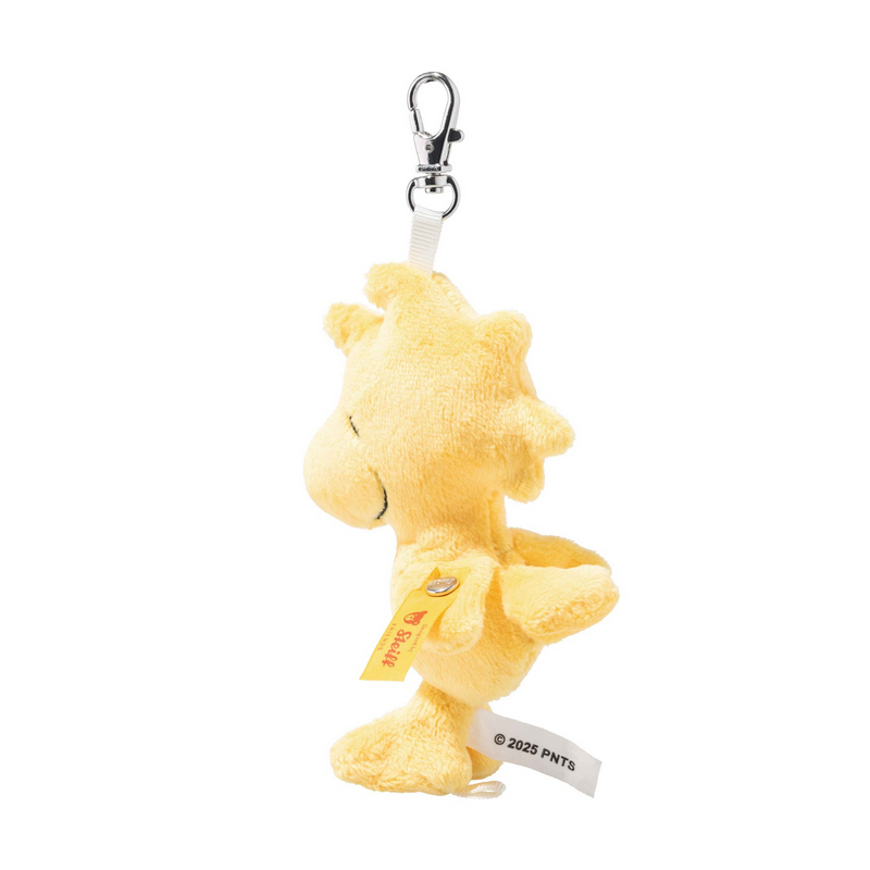 Yellow plush keychain with a tag on a white background