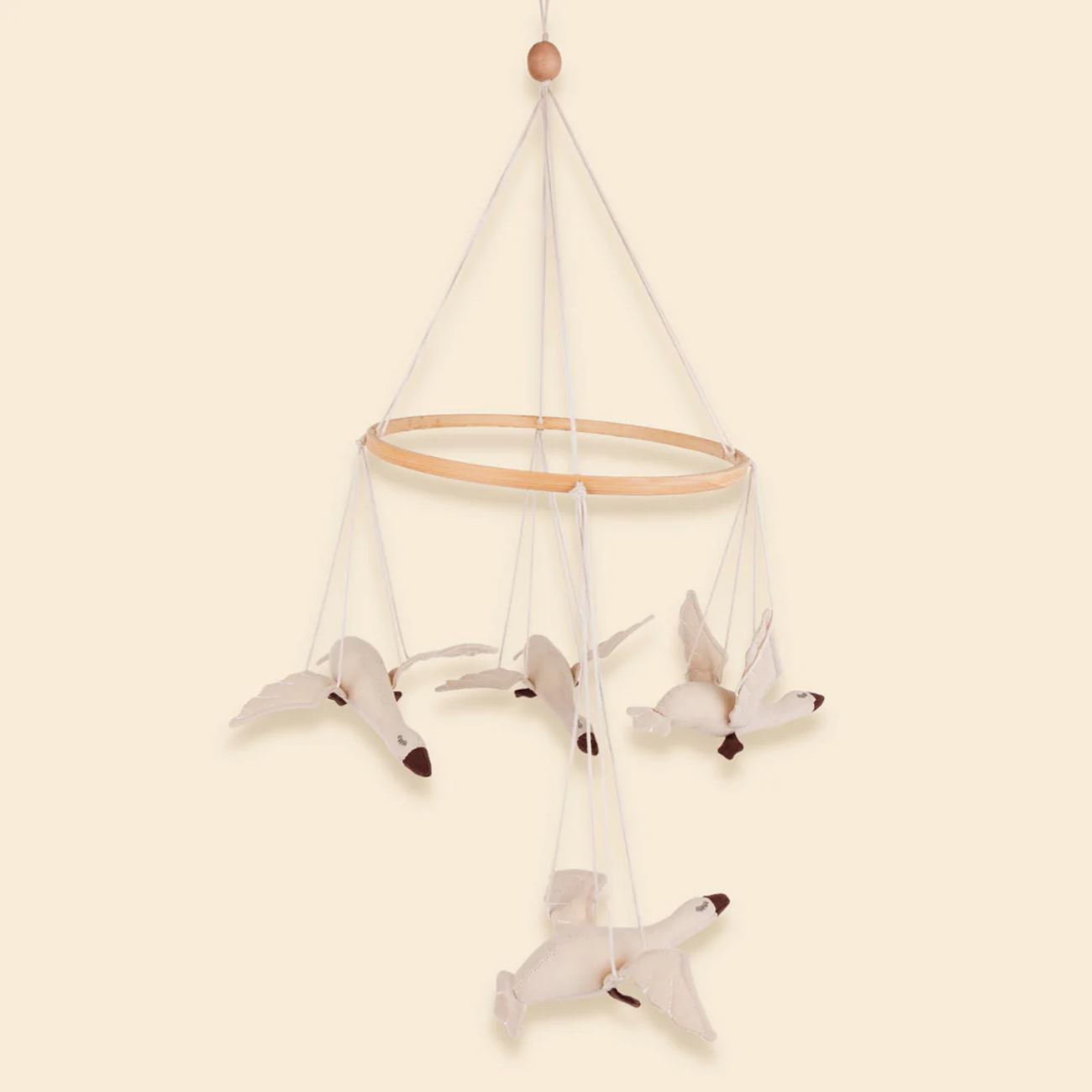 Baby mobile with white birds on a beige background