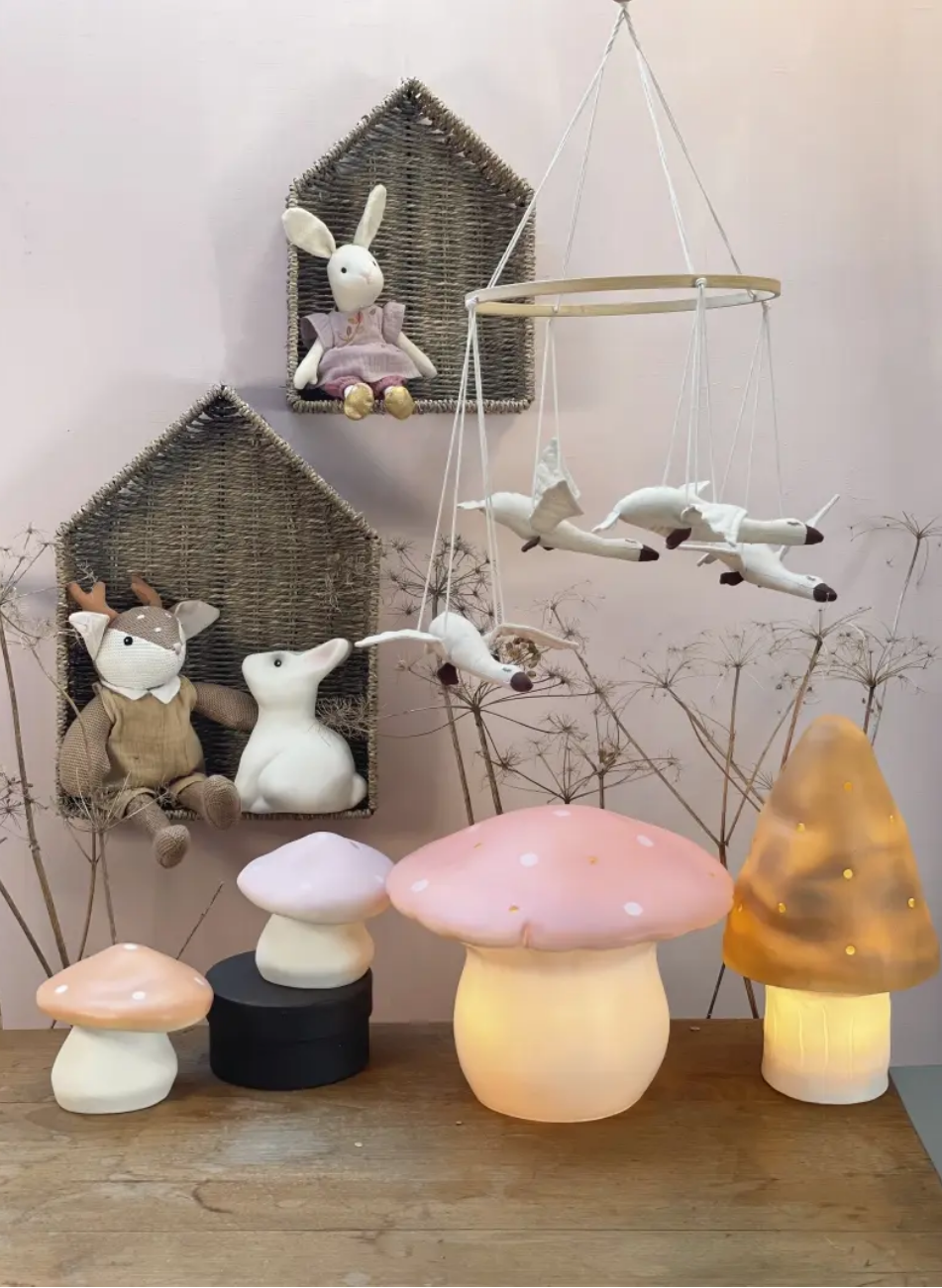 Set of mushroom-shaped lamps on a wooden surface with decorative items in the background.