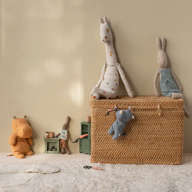 Woven basket with plush toys on a neutral background
