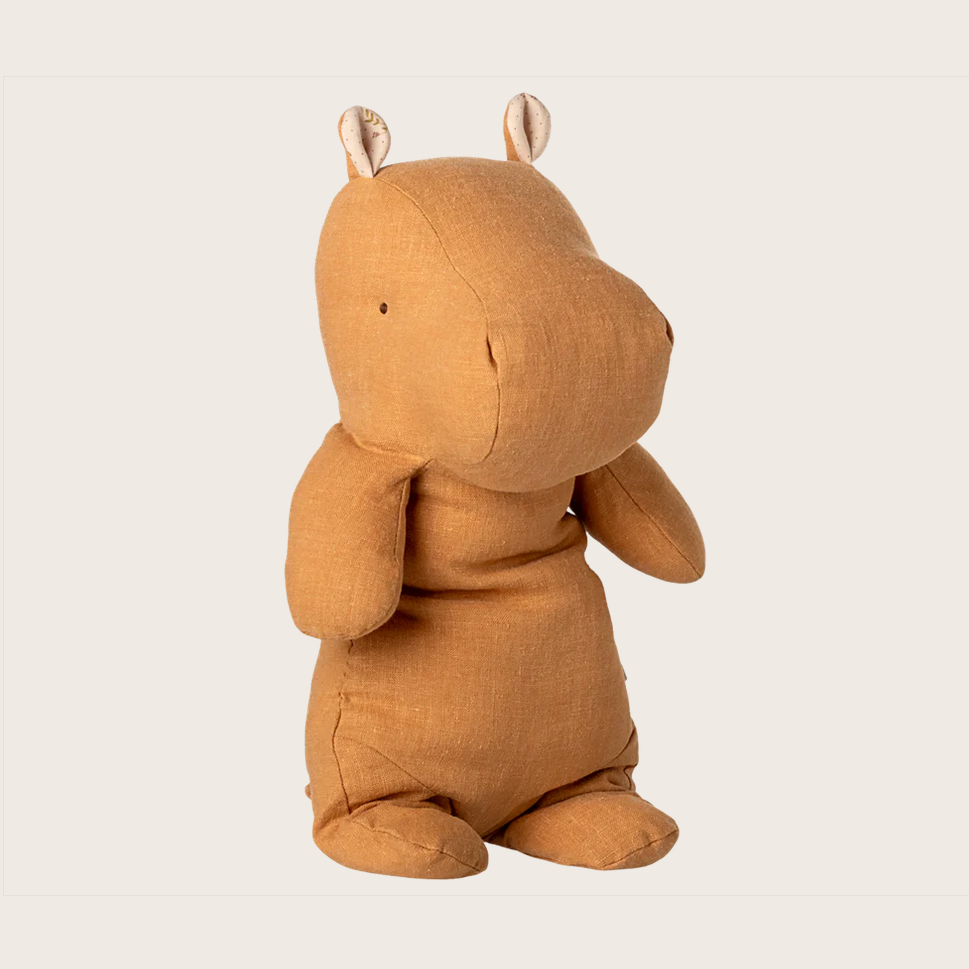 Brown plush hippo toy on a light beige background