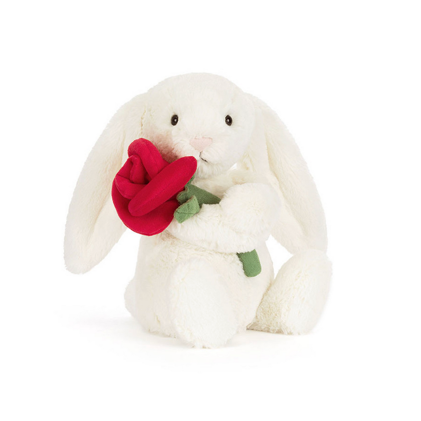 White bunny plush toy holding a red rose on a white background