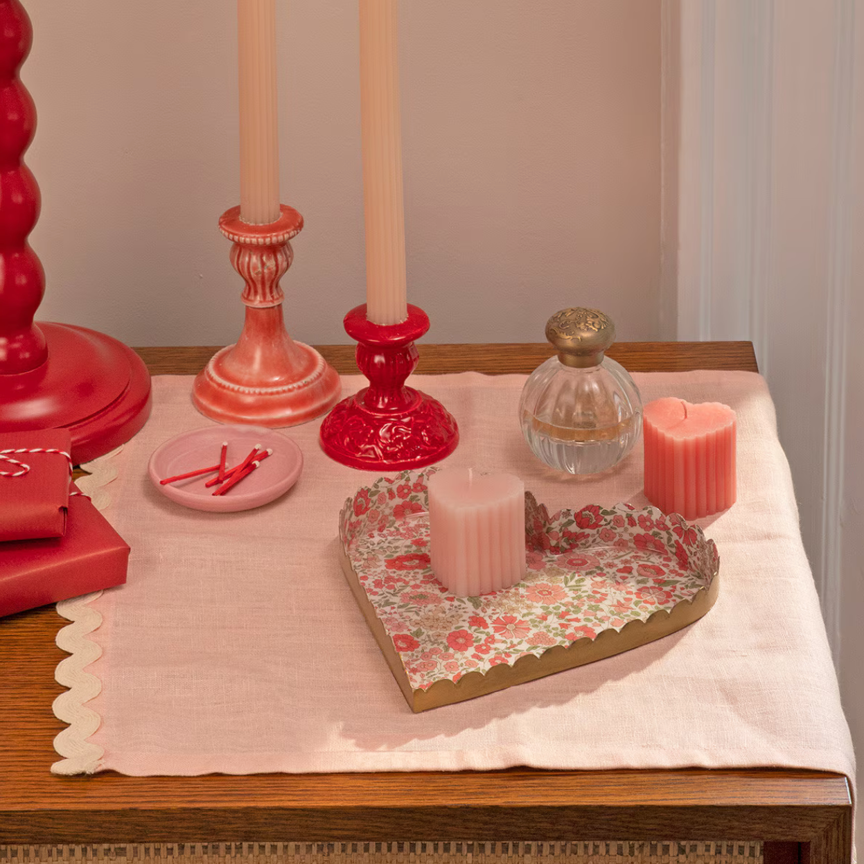 Decorative setting with candles, a tray, and decorative items on a table.