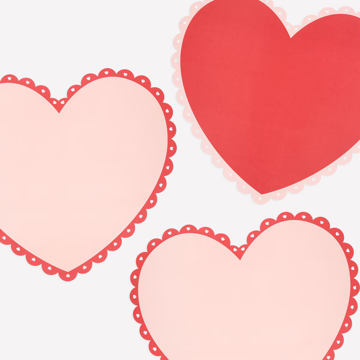 Three heart-shaped placemats with lace detailing on a white background