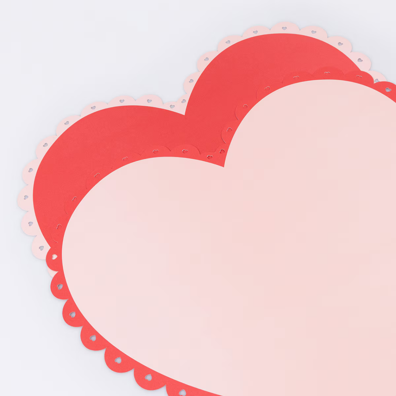 Heart-shaped paper cutouts with scalloped edges on a light gray background